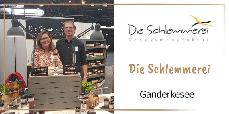 Auf der goldbraun gerahmten WasRegionales-Markenkachel Antje und Frank Dobrin mit ihren Produkten an ihrem Messestand; das Logo von Die Schlemmerei; darunter der Schriftzug Die Schlemmerei, Ganderkesee
