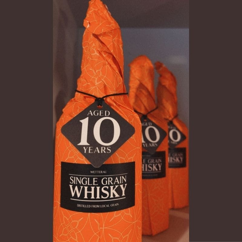 drei 10jaehrige Single Grain Wetterau Whisky Flaschen verpackt in Reihe gestellt